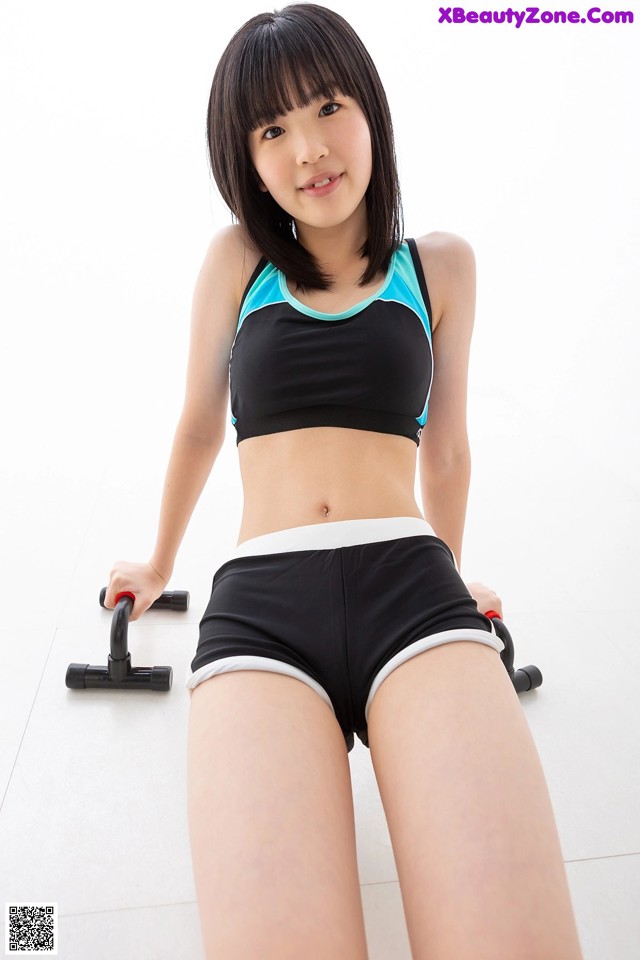 A woman in a black and blue sports bra top and black shorts.