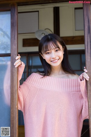A woman standing in front of a wooden door.