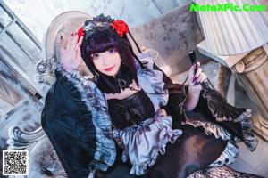 A woman in a black lingerie sitting on a couch.