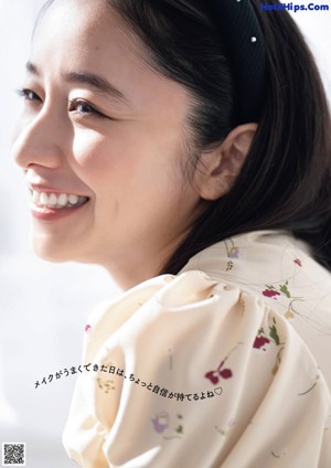 A woman holding a flower in front of her face.