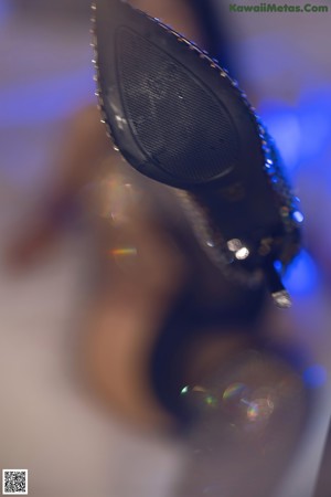 A woman in a fishnet bodysuit standing in front of a mirror.