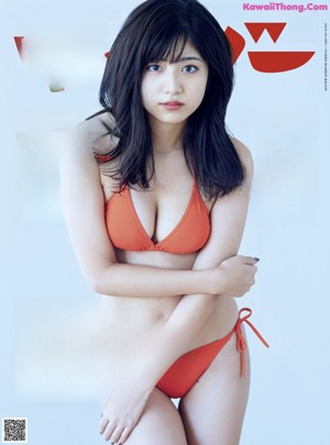 A woman in a red bikini laying on a bed.