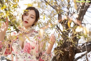 A woman in a floral dress posing for a picture.