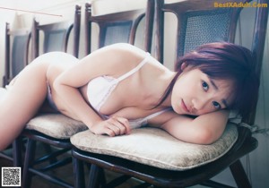 A woman sitting on top of a wooden bench.
