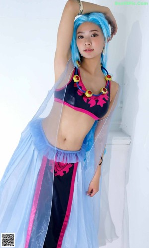 A woman in a bikini and a blue cape holding a sword.