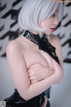 A woman in a black latex outfit with a tattoo on her back.