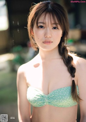 A woman in a blue bikini posing for a picture.
