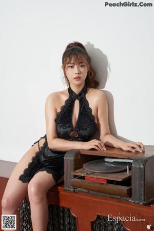 A woman in a black dress laying on a brown chair.