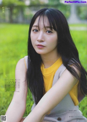 A woman with long black hair wearing a white shirt.