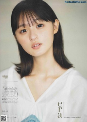 A woman with long black hair wearing a blue shirt.