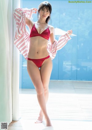 A woman in a bikini sitting on top of a wooden table.