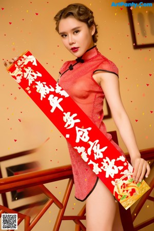 A woman in a red dress is holding red lanterns.