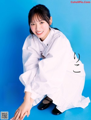 A woman in a white shirt is posing for a magazine.