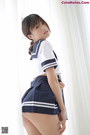 A woman in a school uniform is posing for the camera.