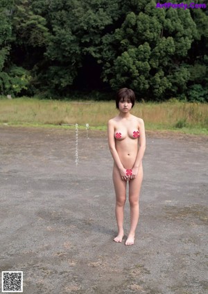 A naked asian woman sitting on a tatami mat.