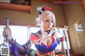 A woman dressed in a red and blue outfit holding two swords.