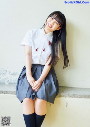 A woman in a school uniform posing for a picture.