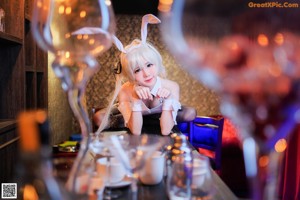 A woman dressed as a bunny standing in front of a bar.