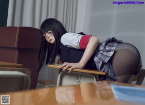 A woman in a school uniform is sitting on a desk.
