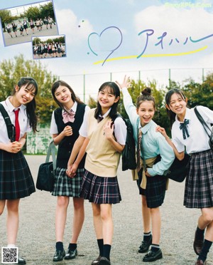 A group of young girls in school uniforms raising their hands.