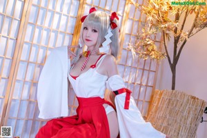 A woman in a white and red dress posing for a picture.